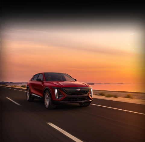 Cadillac LYRIQ driving with sunset behind